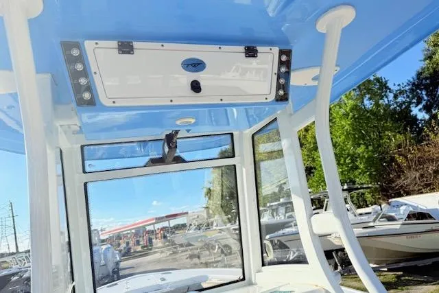 Slide: The Image of 2021 Tidewater 292 CC Adventure boat interior with blue ceiling and window view. - 12