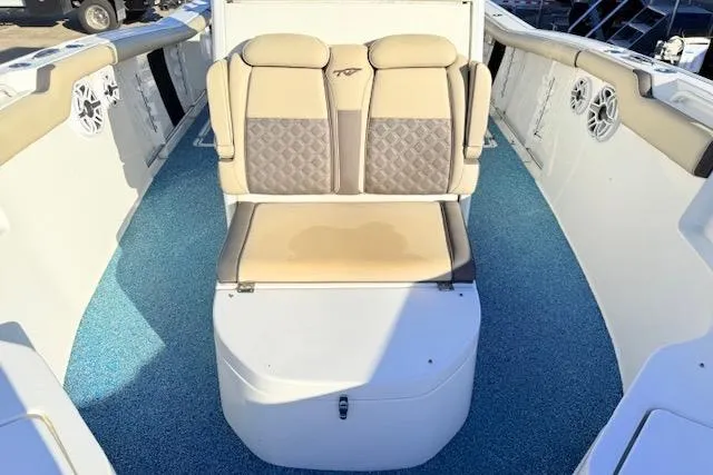 Slide: The Image of 2021 Tidewater 292 CC Adventure boat interior with cushioned seating and blue flooring. - 17
