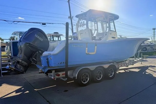 Slide: The Image of 2021 Tidewater 292 CC Adventure boat on trailer, featuring Yamaha engines, in a sunny outdoor setting. - 2