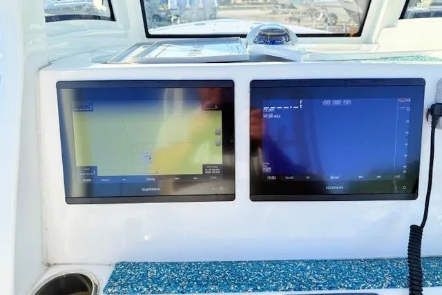 Slide: The Image of 2021 Tidewater 292 CC Adventure boat dashboard with dual Garmin displays. - 20