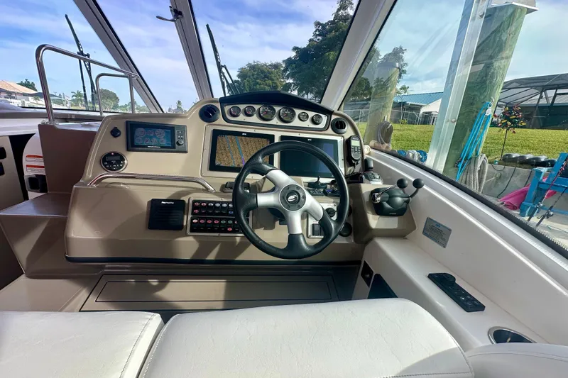 Slide: The Image of 2011 Cruisers Yachts 420 Sports Coupe helm with modern navigation controls and steering wheel. - 11