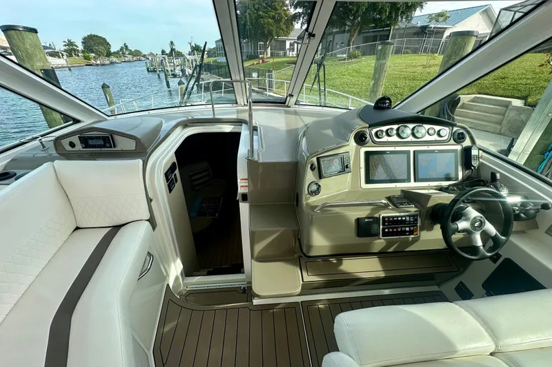 Slide: The Image of 2011 Cruisers Yachts 420 Sports Coupe cockpit with modern navigation system and luxurious seating. - 12