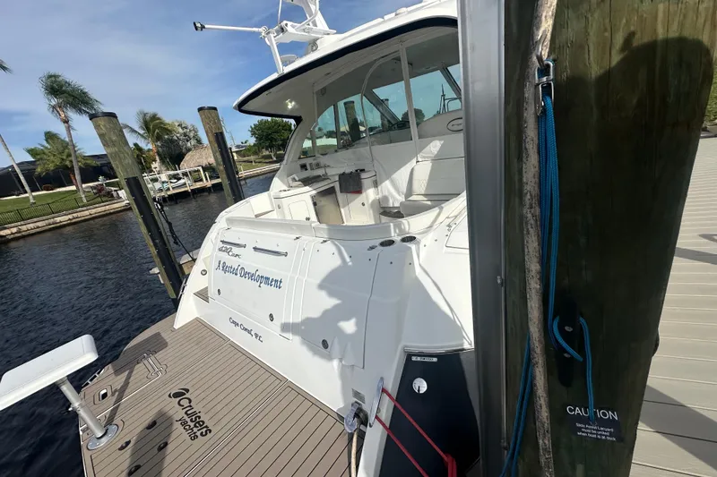 Slide: The Image of 2011 Cruisers Yachts 420 Sports Coupe docked, showcasing sleek design and spacious deck. - 4