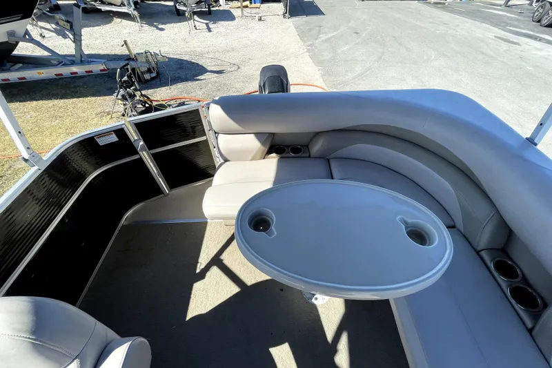 Slide: The Image of 2014 Starcraft Stardeck 190 Cruise pontoon boat with canopy, parked outdoors under cloudy sky. - 14