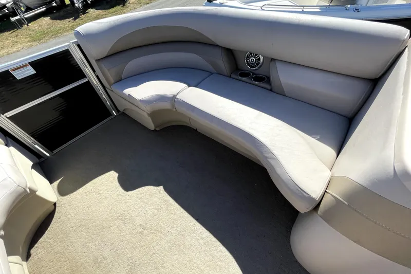 Slide: The Image of 2014 Starcraft Stardeck 190 Cruise boat interior with seating and steering wheel, parked outdoors. - 18