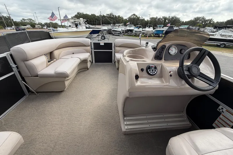 Slide: The Image of 2014 Starcraft Stardeck 190 Cruise boat interior with beige seating and steering console. - 21