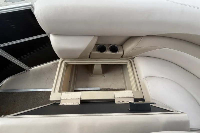 Slide: The Image of 2014 Starcraft Stardeck 190 Cruise boat interior with open storage compartment and cup holders. - 50