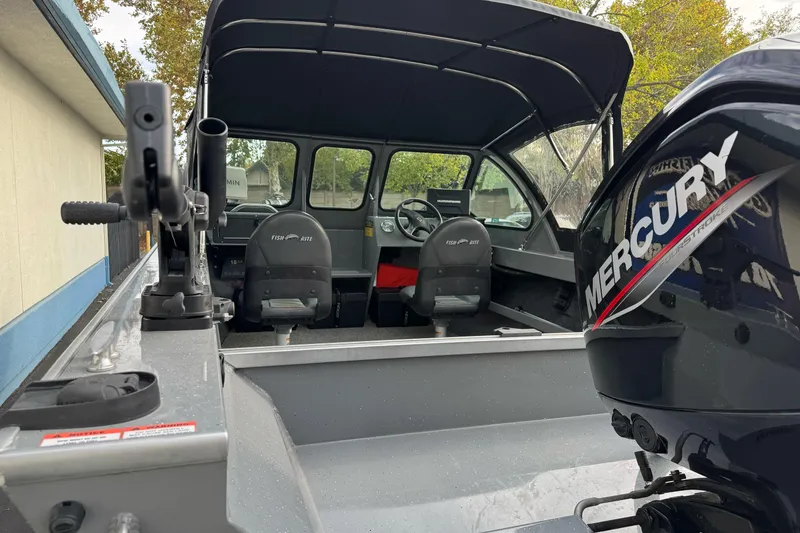 Slide: The Image of 2018 Fish Rite 16.5 Stalker boat interior with Mercury engine, featuring seating and controls. - 11