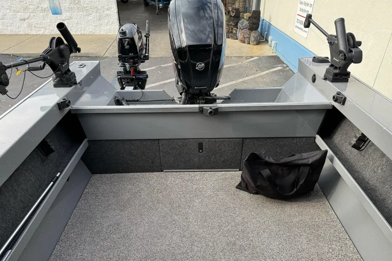 Slide: The Image of 2018 Fish Rite 16.5 Stalker boat interior with motor and fishing rod holders. - 13