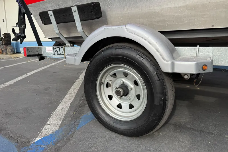 Slide: The Image of Trailer wheel of 2018 Fish Rite 16.5 Stalker boat in parking lot. - 9