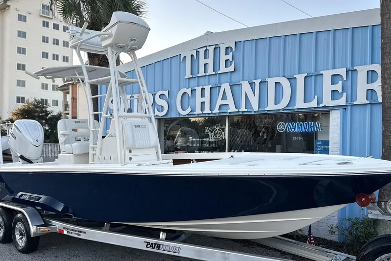 The Image of 2026 Pathfinder 2500 Hybrid boat on trailer outside marine store. - 0