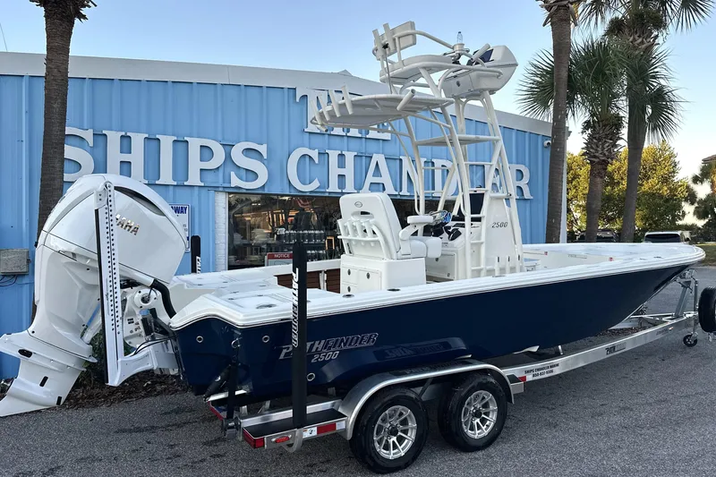 Slide: The Image of 2026 Pathfinder 2500 Hybrid boat on trailer outside Ships Chandler store. - 1