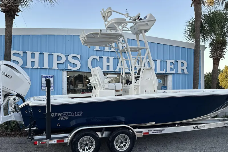 Slide: The Image of 2026 Pathfinder 2500 Hybrid boat on trailer outside Ships Chandler store. - 2