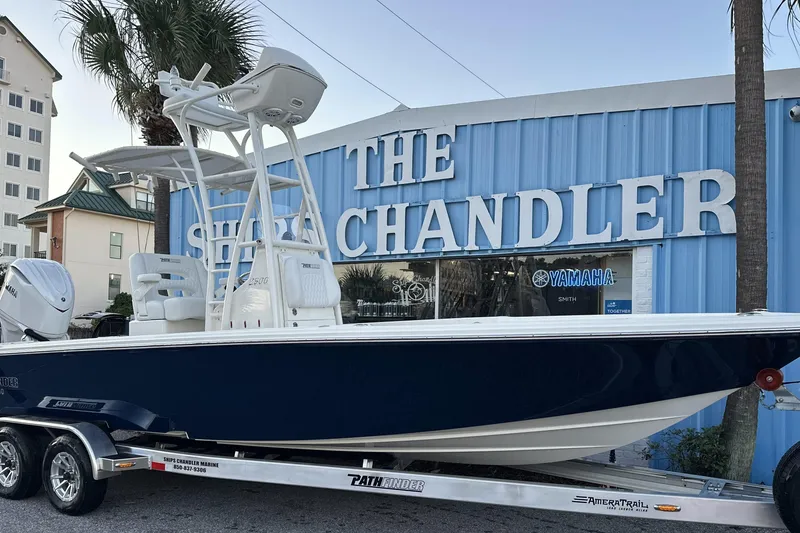Slide: The Image of 2026 Pathfinder 2500 Hybrid boat on trailer outside marine store. - 4