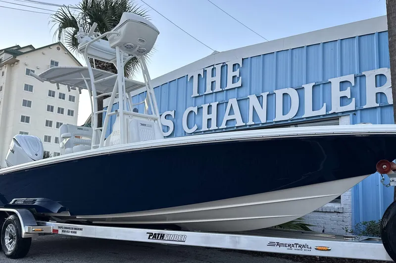 Slide: The Image of 2026 Pathfinder 2500 Hybrid boat on trailer outside marine store. - 5