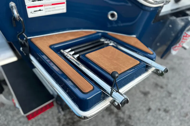 Slide: The Image of 2026 Pathfinder 2500 Hybrid boat ladder with wood accents and metal rails. - 9