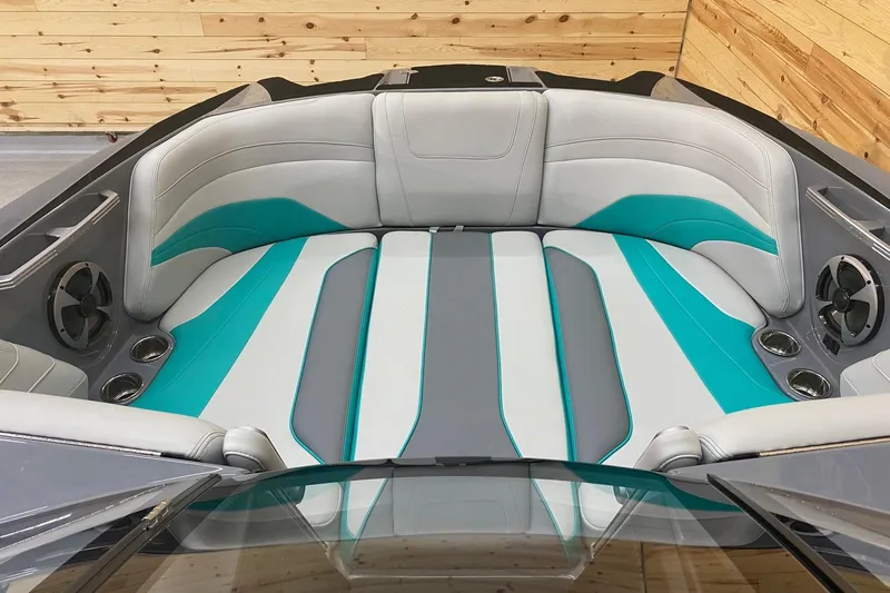 Slide: The Image of 2019 Malibu Wakesetter 24 MXZ interior with teal and gray seating, cup holders, and speakers. - 10