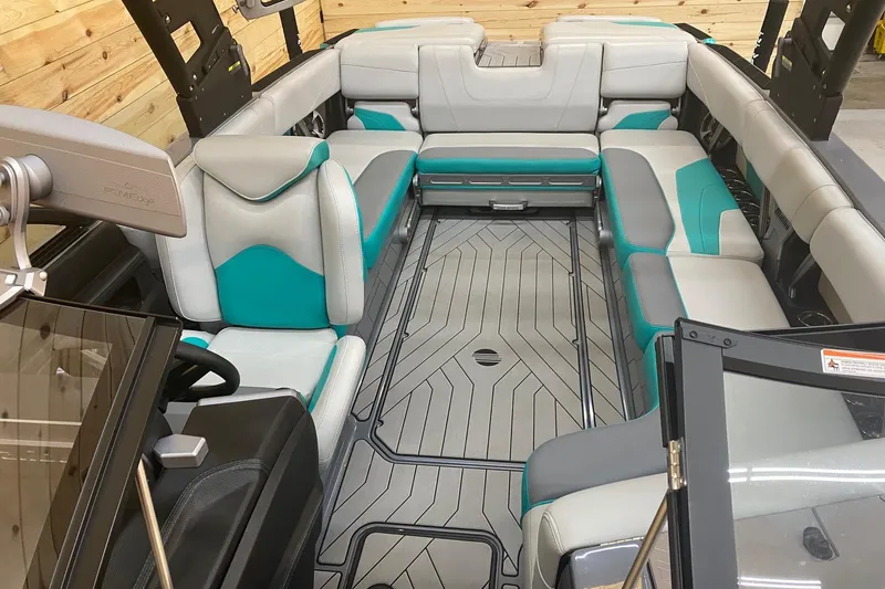 Slide: The Image of 2019 Malibu Wakesetter 24 MXZ interior with teal and gray seating, modern design. - 11