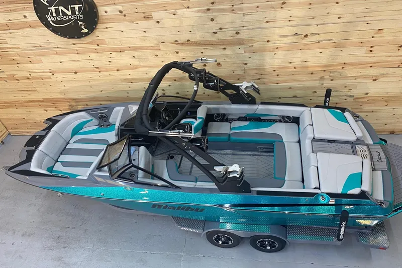 Slide: The Image of 2019 Malibu Wakesetter 24 MXZ boat with teal and gray interior, displayed indoors. - 5