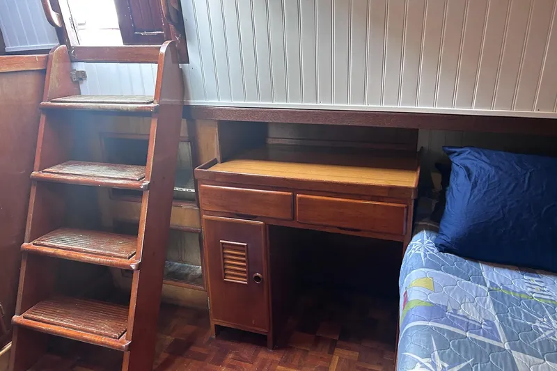 Slide: The Image of 1977 Marine Trader 40 Double Cabin interior with wooden stairs, desk, and bed. - 17