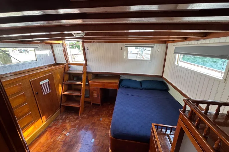 Slide: The Image of 1977 Marine Trader 40 Double Cabin interior with wood paneling and cozy bed. - 20