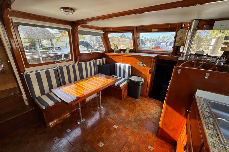 Slide: The Image of 1977 Marine Trader 40 Double Cabin interior with striped seating and wooden table. - 27