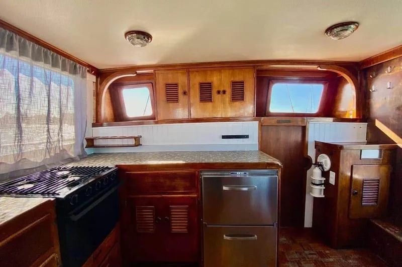 Slide: The Image of 1977 Marine Trader 40 Double Cabin interior with wood cabinetry and kitchen appliances. - 29