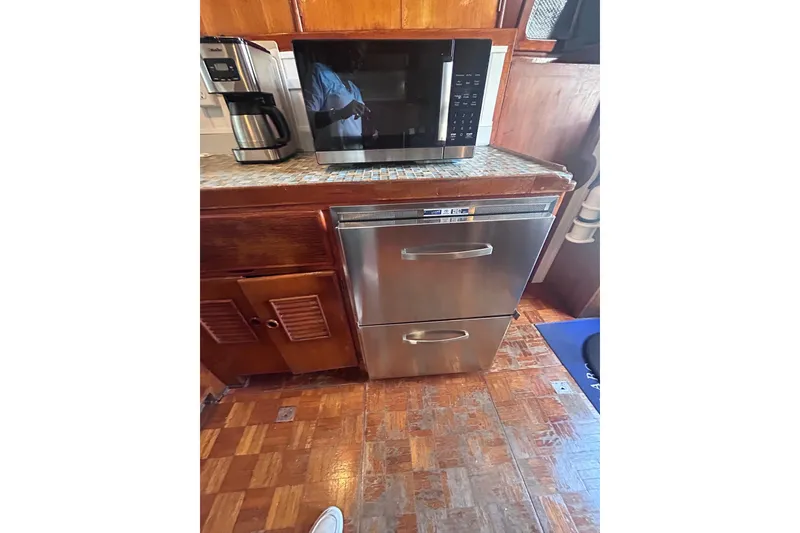 Slide: The Image of 1977 Marine Trader 40 Double Cabin kitchen with microwave and stainless steel appliances. - 30