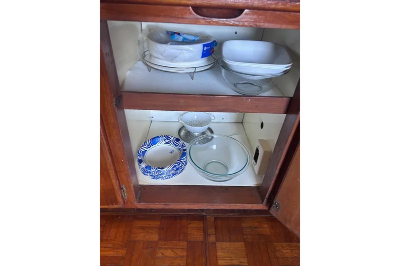 Slide: The Image of Cabinet with dishes and bowls inside a 1977 Marine Trader 40 Double Cabin. - 33