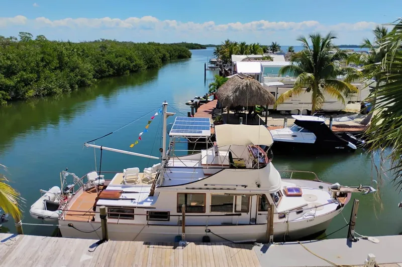 Slide: The Image of 1977 Marine Trader 40 Double Cabin yacht docked by a scenic canal with lush greenery. - 39