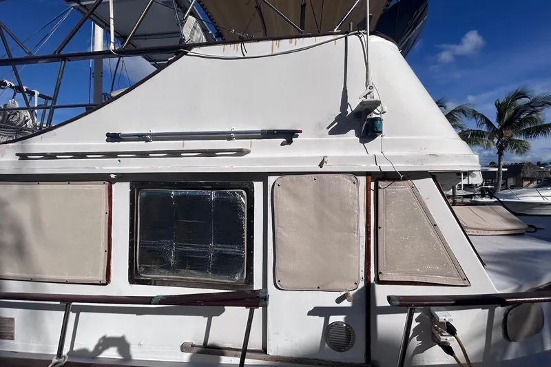 Slide: The Image of 1977 Marine Trader 40 Double Cabin boat exterior with covered windows and railing. - 4