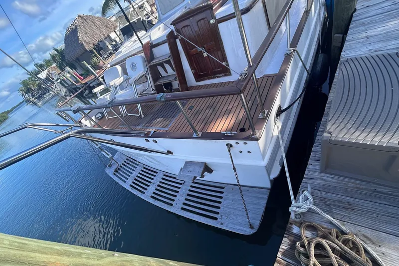 Slide: The Image of 1977 Marine Trader 40 Double Cabin yacht docked, featuring wooden deck and railings. - 5