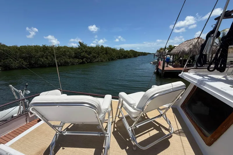 Slide: The Image of 1977 Marine Trader 40 Double Cabin yacht with chairs overlooking serene waterway. - 9