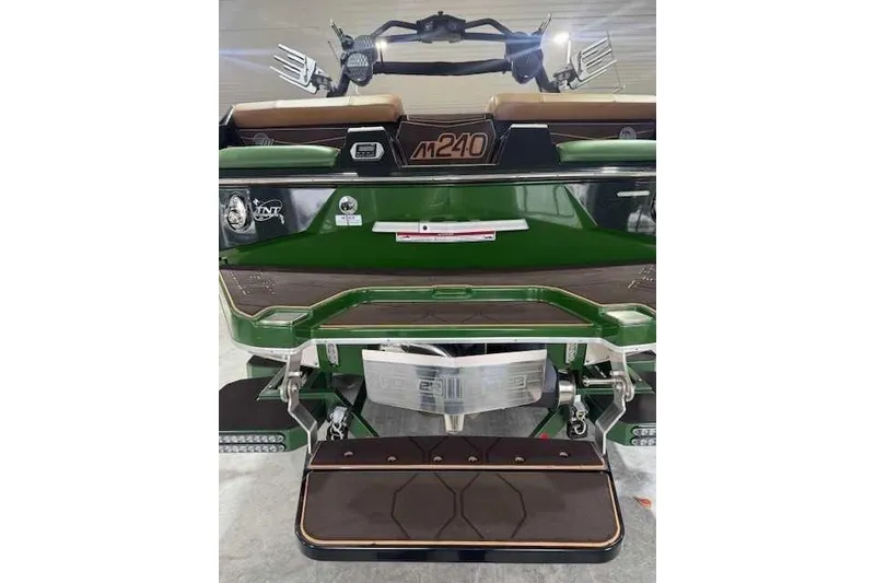 Slide: The Image of 2022 Malibu M240 boat rear view, featuring green and brown design with step platform. - 15