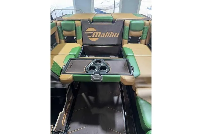 Slide: The Image of Interior of 2022 Malibu M240 boat with green and tan seating and cup holders. - 6