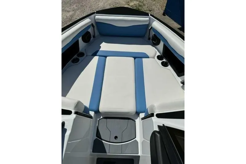 Slide: The Image of 2024 Axis T235 boat interior with blue and white seating, cup holders, and storage compartments. - 7