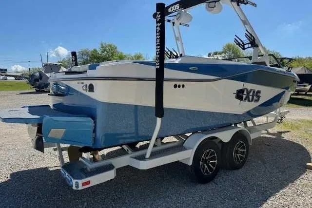 Slide: The Image of 2024 Axis T235 boat on trailer, blue and white design, parked outdoors. - 8