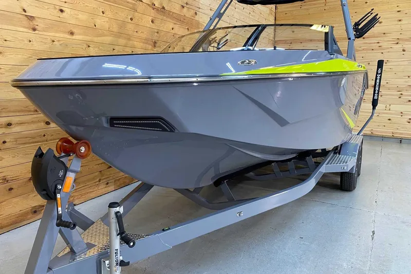Slide: The Image of 2024 Axis T235 boat in showroom, gray and lime accents, on trailer. - 3