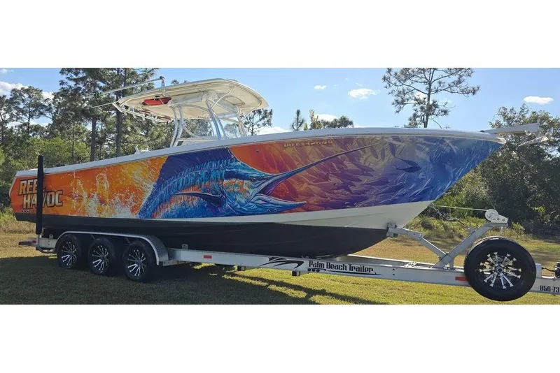 Slide: The Image of 2013 Sailfish 320 CC boat with vibrant marine-themed artwork on a trailer. - 10