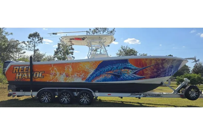 Slide: The Image of 2013 Sailfish 320 CC boat with vibrant marlin artwork on trailer. - 11