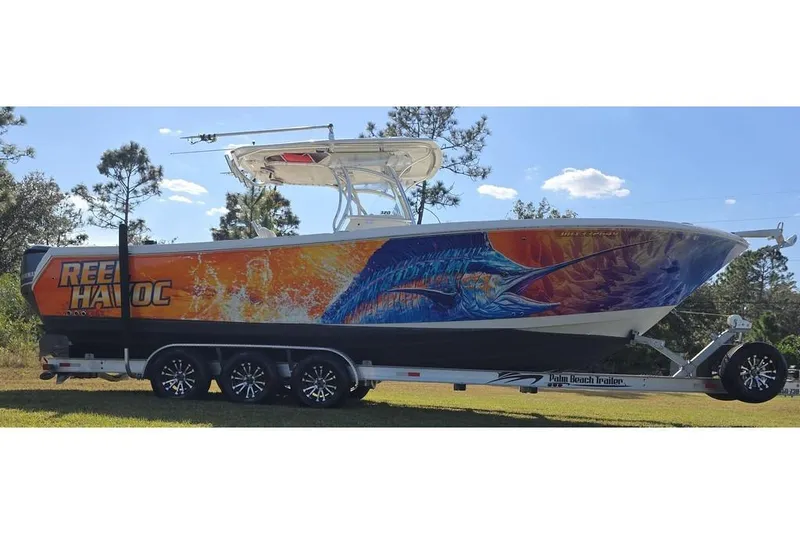 Slide: The Image of 2013 Sailfish 320 CC boat with vibrant marine-themed artwork on trailer. - 12