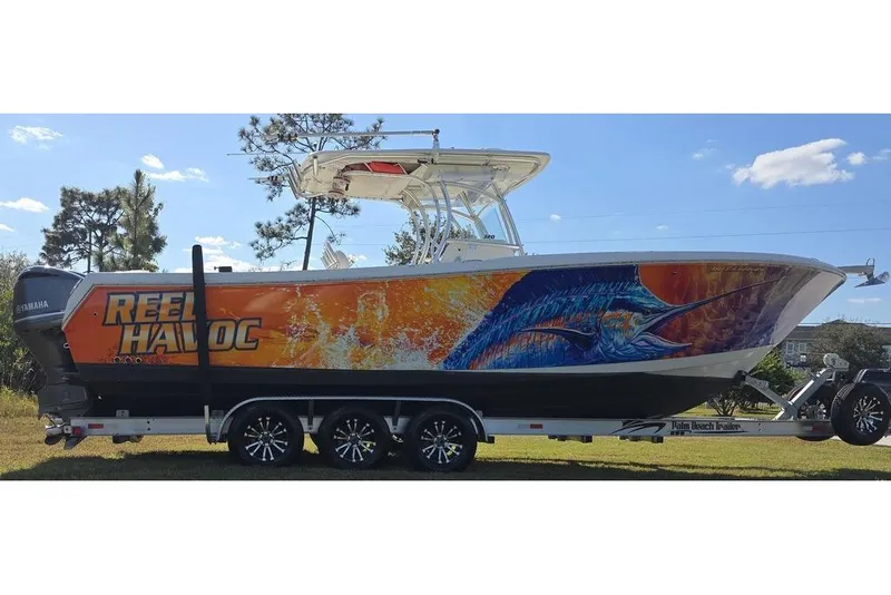 Slide: The Image of 2013 Sailfish 320 CC boat with vibrant marlin artwork on trailer. - 13