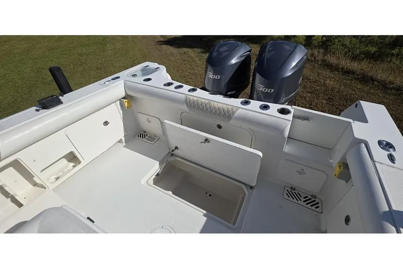 Slide: The Image of 2013 Sailfish 320 CC boat interior with dual 300 HP engines, spacious deck, and storage compartments. - 17