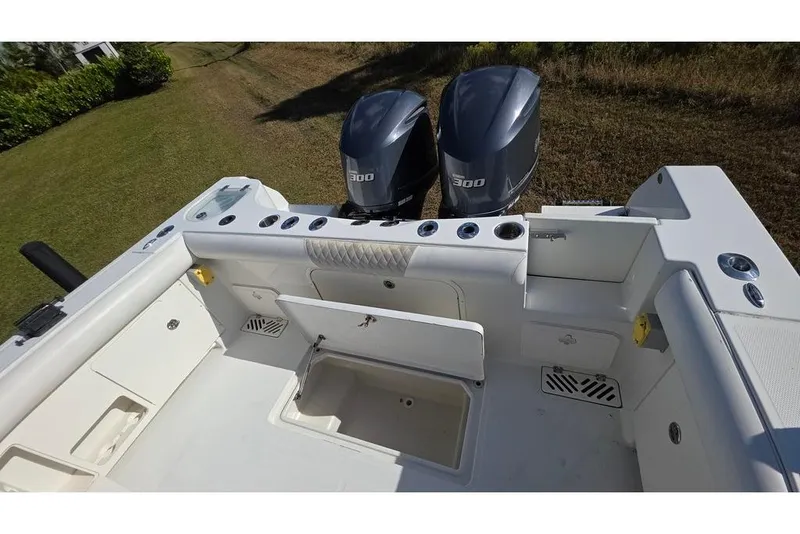 Slide: The Image of 2013 Sailfish 320 CC boat with dual 300 horsepower engines, featuring spacious deck layout. - 18