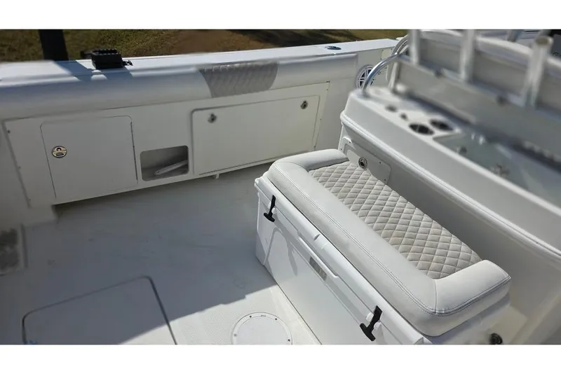 Slide: The Image of 2013 Sailfish 320 CC boat interior with cushioned seating and storage compartments. - 20