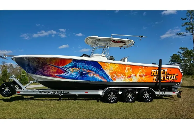 Slide: The Image of 2013 Sailfish 320 CC boat with vibrant marlin artwork on trailer. - 3