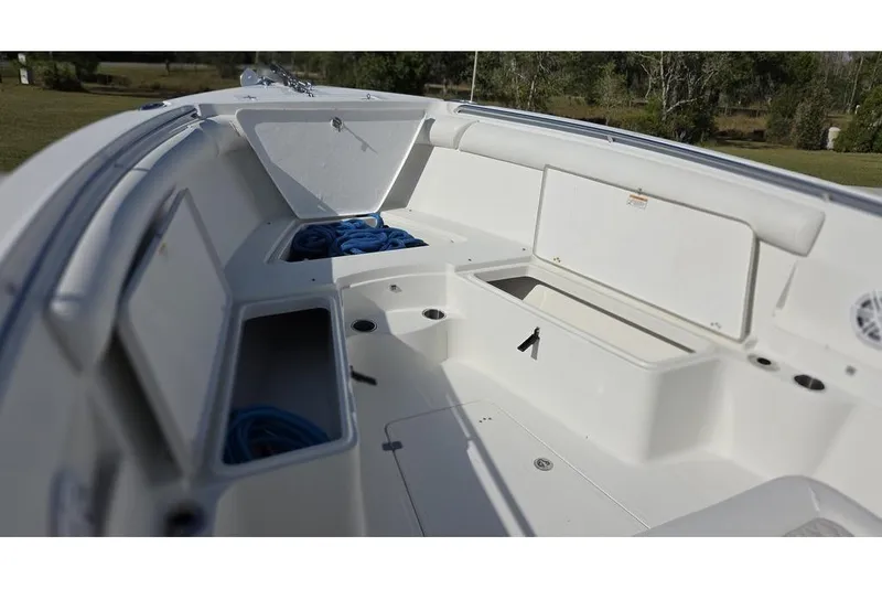 Slide: The Image of 2013 Sailfish 320 CC boat interior with open storage compartments and coiled ropes. - 31