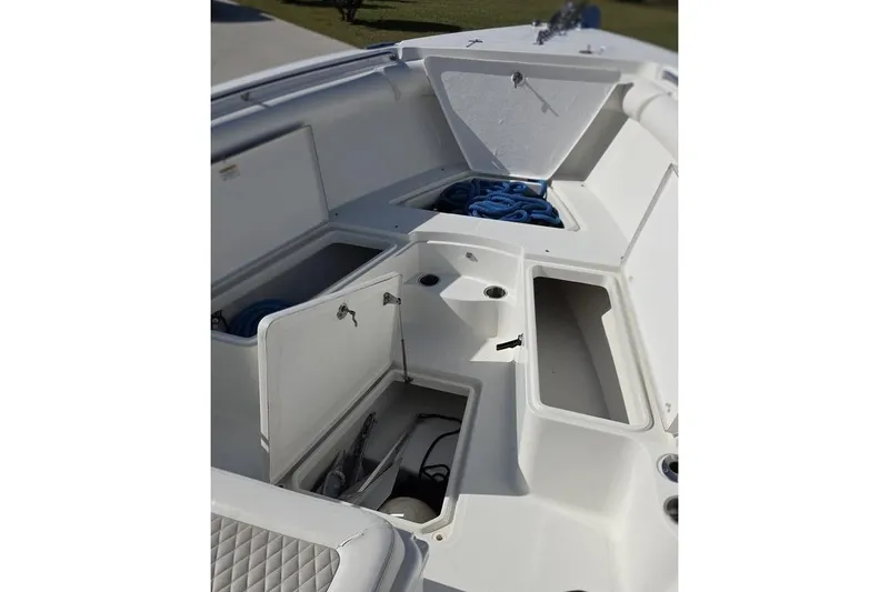 Slide: The Image of 2013 Sailfish 320 CC boat storage compartments with open hatches and coiled ropes. - 32