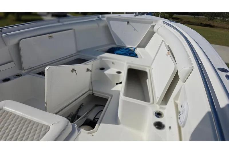 Slide: The Image of 2013 Sailfish 320 CC boat interior with open storage compartments and seating. - 33