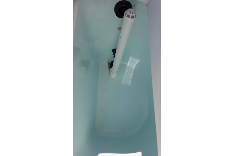 Slide: The Image of 2013 Sailfish 320 CC livewell interior with water and drain pipe. - 42